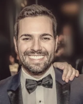 Chris Linteris smiling, in a tuxedo and bow tie